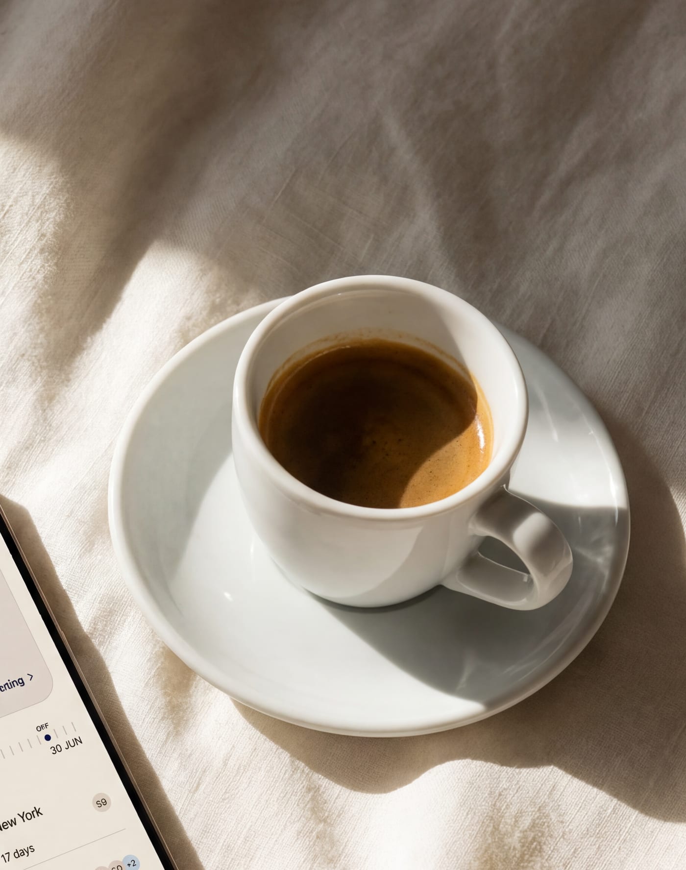 Morning light over cream linen and an espresso — a quiet day off